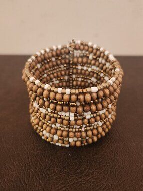 Wrap bracelet features gold beads in brown and white colors